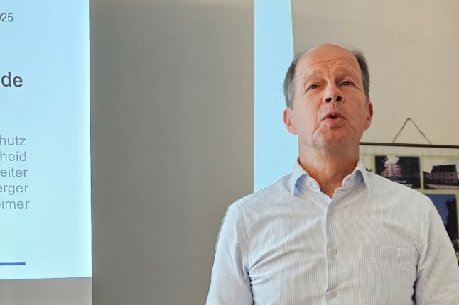 Ein Mann steht vor einer Präsentation und redet