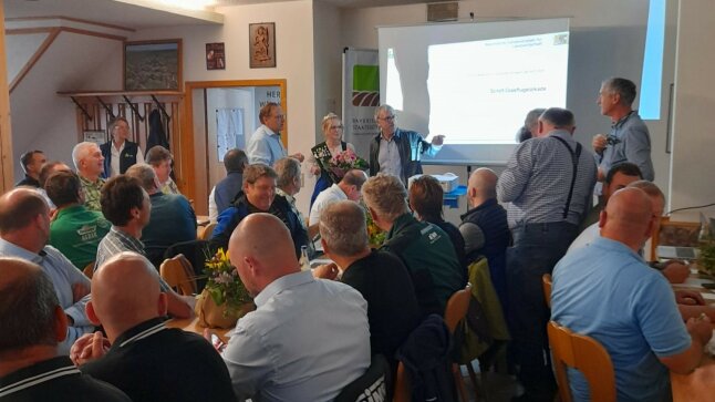 viele Gäste sitzen in einem Besprechungsraum vor einer Präsentation