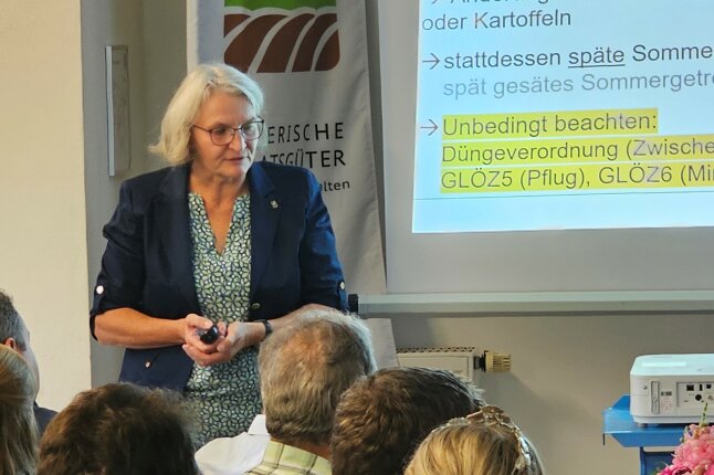 Eine Frau steht vor einer Präsentation und redet