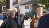 Ein Mann erklärt mit einer Flasche gelber Flüssigkeit einer Menschenmenge HVO