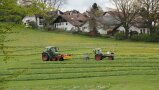 zwei grüne Traktoren auf Wiese